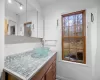 Bathroom with vanity, a healthy amount of sunlight, and backsplash