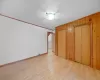 Unfurnished bedroom with wood finished floors, baseboards, wood walls, and ornamental molding