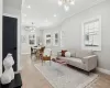 Living area with plenty of natural light, an inviting chandelier, and ornamental molding