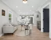 Living room with baseboards, light wood-type flooring, ornamental molding, electric panel, and recessed lighting