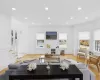 Living room with stairs, light wood-style flooring, recessed lighting, and wainscoting