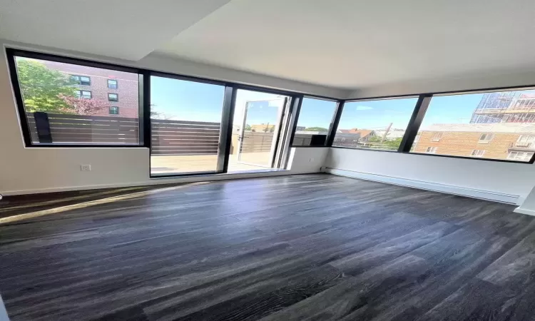 Spare room with baseboards and wood finished floors