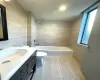 Full bath with vanity, tile walls, toilet, and bathtub / shower combination