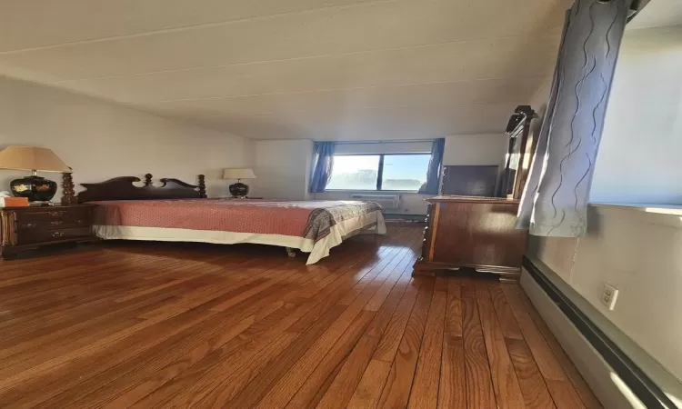 Bedroom with dark wood-style flooring