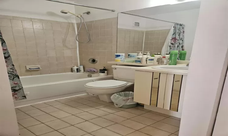 Full bath featuring vanity, visible vents, shower / bath combo, tile patterned flooring, and toilet