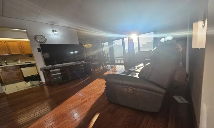 Living area featuring wood-type flooring and a notable chandelier