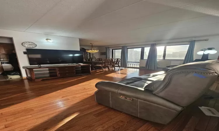 Living room with hardwood / wood-style floors, a notable chandelier, and a textured ceiling