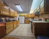 Kitchen with under cabinet range hood, gas stove, tasteful backsplash, and freestanding refrigerator