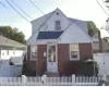 Cape Cod-style house with a fenced front yard and brick siding