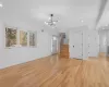 Unfurnished living room featuring baseboards, a chandelier, stairs, recessed lighting, and light wood-style flooring