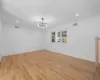 Empty room featuring a notable chandelier, visible vents, light wood-style flooring, and baseboards