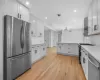 Kitchen featuring visible vents, light wood-style flooring, appliances with stainless steel finishes, light countertops, and extractor fan