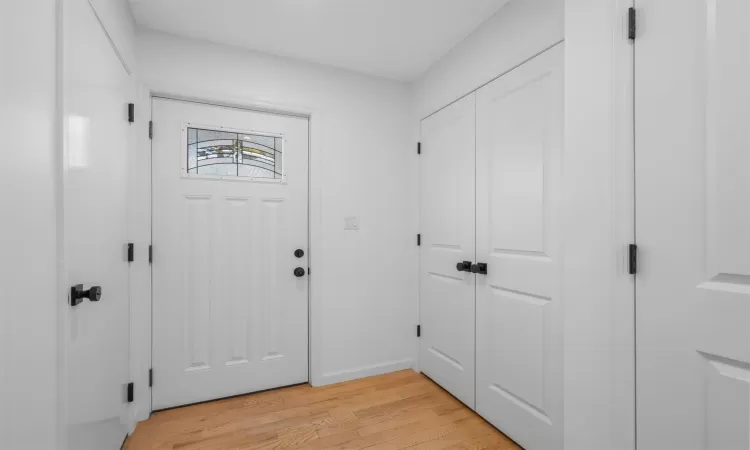 Entrance foyer with baseboards and light wood-style floors