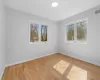 Spare room featuring wood finished floors, plenty of natural light, baseboards, and visible vents