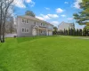 View of front facade featuring a front yard, central AC unit, fence, driveway, and a garage