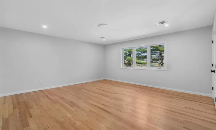 Spare room with visible vents, recessed lighting, baseboards, and light wood-style floors