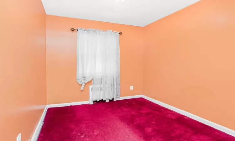 Empty room featuring carpet flooring and baseboards