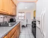 Kitchen featuring black range with gas cooktop, backsplash, white refrigerator with ice dispenser, and a sink