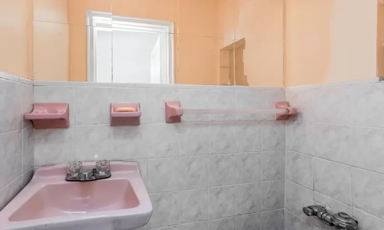 Bathroom with tile walls and a sink