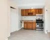 Kitchen featuring under cabinet range hood, brown cabinetry, stainless steel range with gas cooktop, and a sink