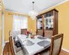 Dining space with an inviting chandelier, crown molding, baseboards, and wood finished floors