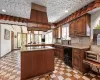 Kitchen featuring a sink, black electric cooktop, light stone countertops, and dishwashing machine