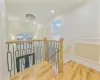 Stairs featuring plenty of natural light, wood-type flooring, crown molding, and a chandelier