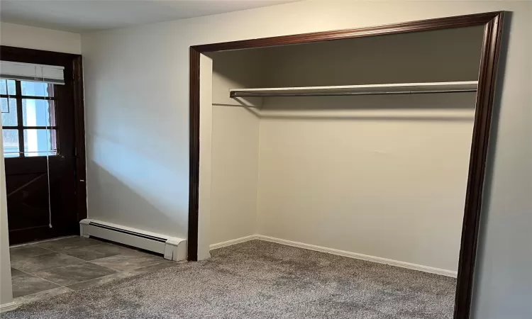 Entry way with hard floor meeting carpet and a large coat closet