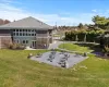 Rear view of property featuring a patio area, a yard, and roof with shingles