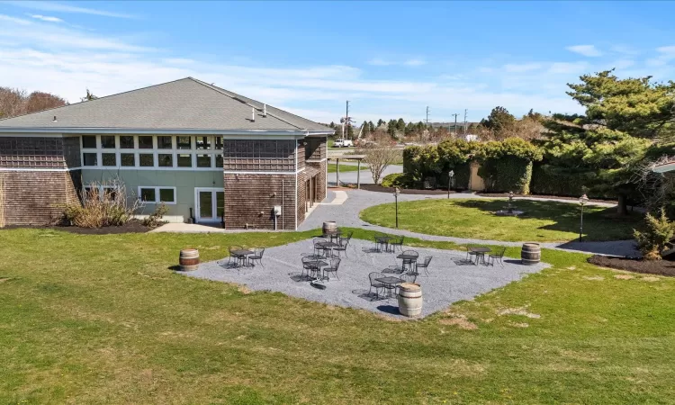 Rear view of property featuring a patio area, a yard, and roof with shingles