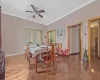 Dining room featuring light wood-type flooring, baseboards, ceiling fan, and ornamental molding