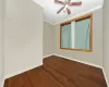 Spare room with baseboards, a ceiling fan, ornamental molding, and dark wood finished floors