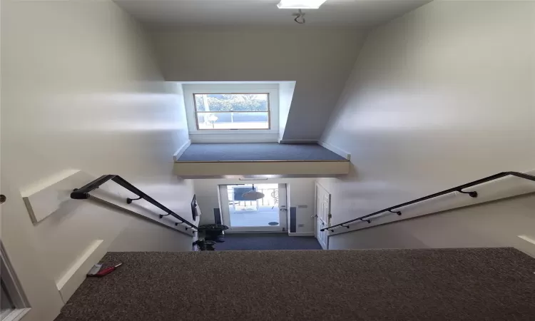 Stairs featuring a high ceiling and a healthy amount of sunlight