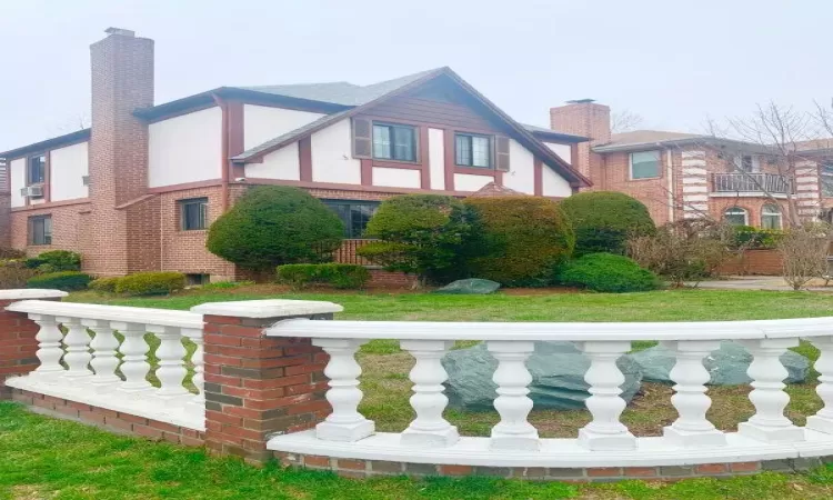 View of property exterior with brick, siding, and chimney.