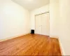 Unfurnished bedroom with wood finished floors, baseboards, and a closet