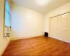 Unfurnished bedroom with cooling unit, wood finished floors, baseboards, and a closet