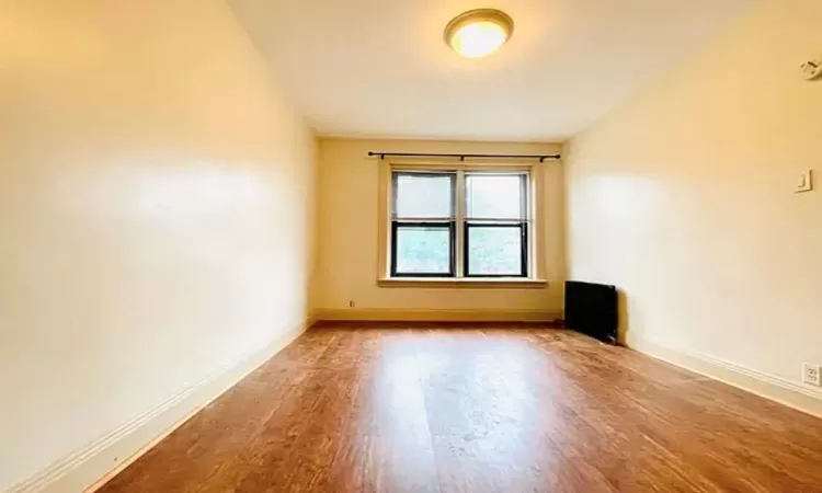 Unfurnished room featuring baseboards and wood finished floors