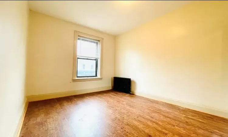 Empty room featuring wood finished floors and baseboards