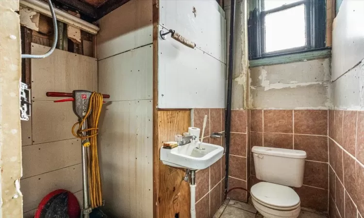 Bathroom with tile walls and toilet