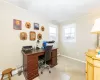 Office space featuring light colored carpet, baseboards, and a baseboard radiator