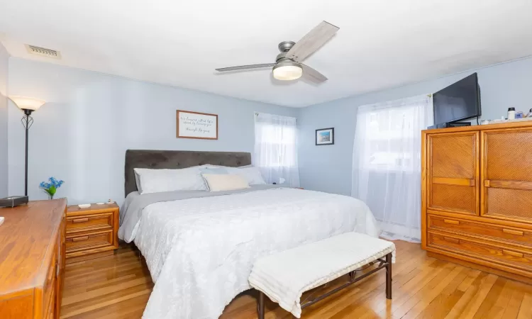 Bedroom with visible vents, a ceiling fan, and light wood finished floors