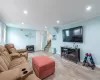 Living area featuring visible vents, wood finished floors, stairs, recessed lighting, and a wood stove