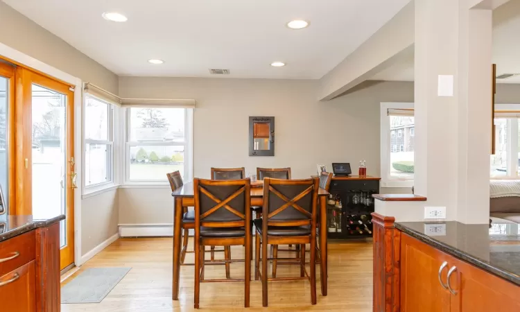 Dining room with light wood-type flooring, visible vents, recessed lighting, a baseboard radiator, and baseboards