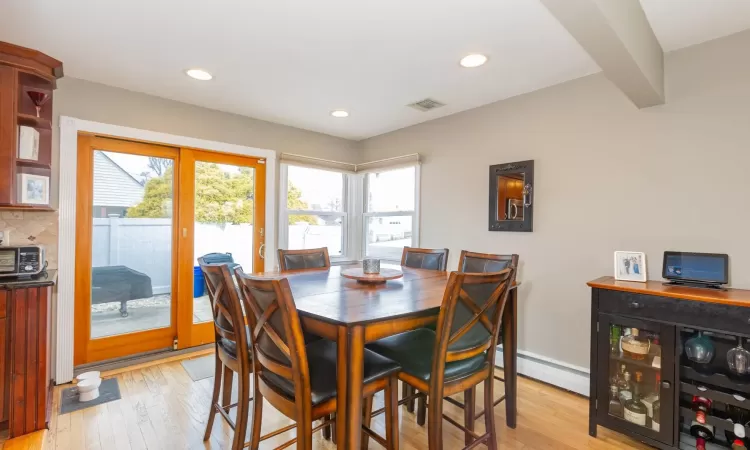 Dining room featuring visible vents, beam ceiling, recessed lighting, light wood-style floors, and a baseboard heating unit