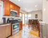 Kitchen with decorative backsplash, brown cabinets, appliances with stainless steel finishes, and dark stone counters