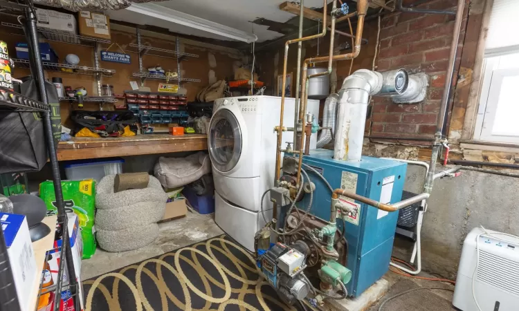 Laundry area featuring laundry area, brick wall, and a heating unit