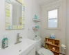 Bathroom featuring a sink, a baseboard heating unit, toilet, and crown molding