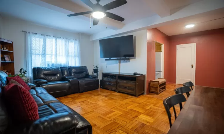 Living area featuring beam ceiling and a ceiling fan