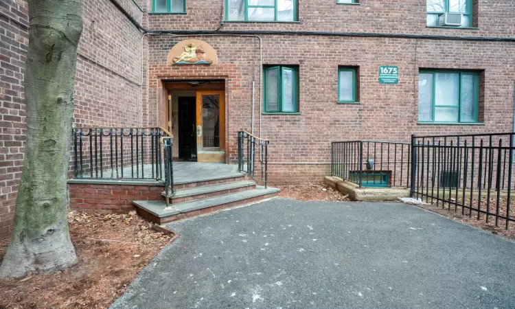 Entrance to property featuring fence and brick siding