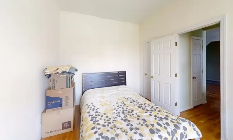 Bedroom with wood finished floors and baseboards